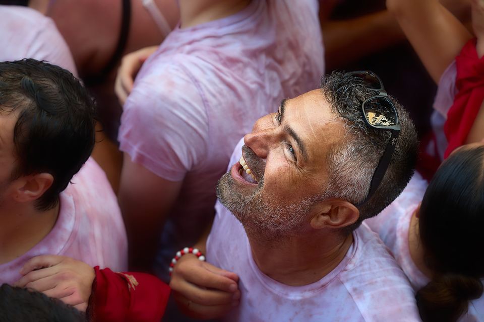 Hombre sonriente entre la multitud durante el Chupinazo de San Fermín en Pamplona