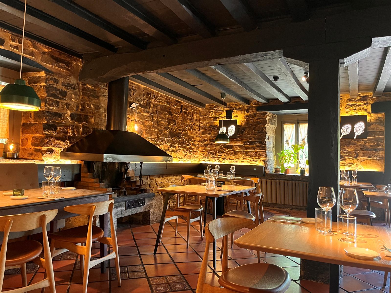 Comedor de un restaurante con paredes de piedra y mesas preparadas