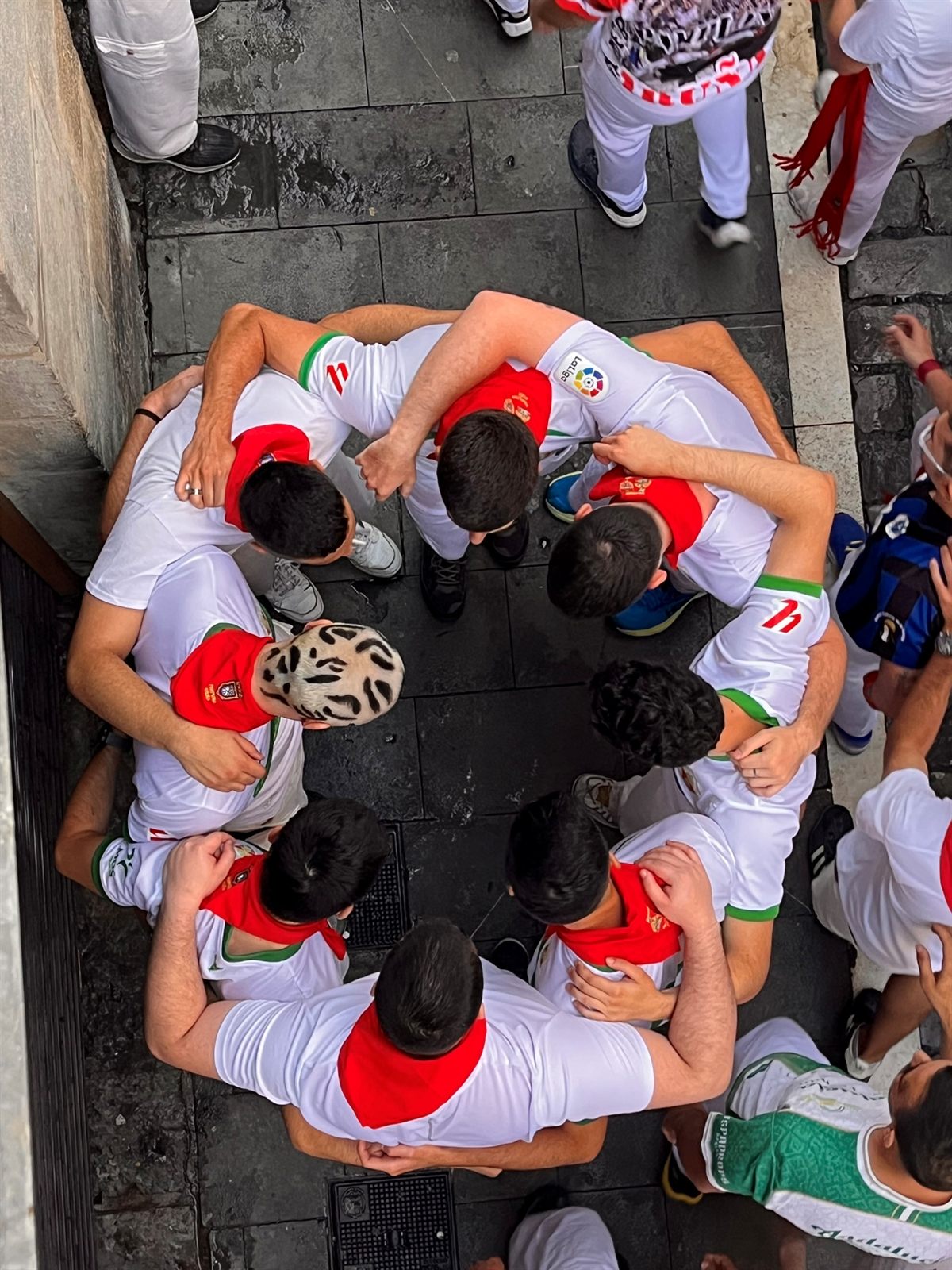 Grupo de mozos abrazados en círculo durante San Fermín