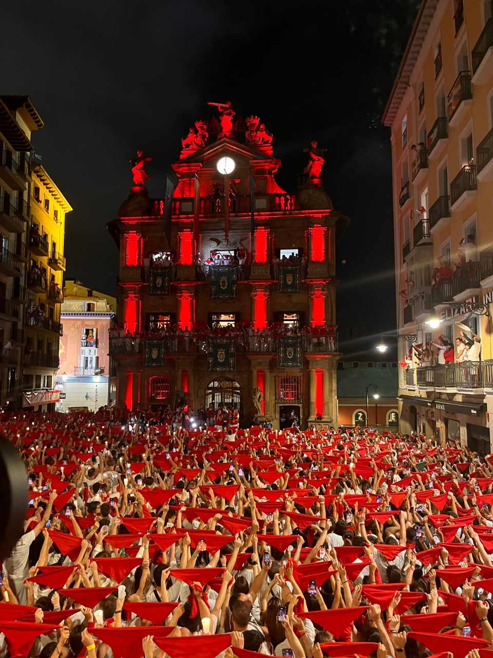 Pobre de mí de San Fermín frente al Ayuntamiento de Pamplona iluminado en rojo