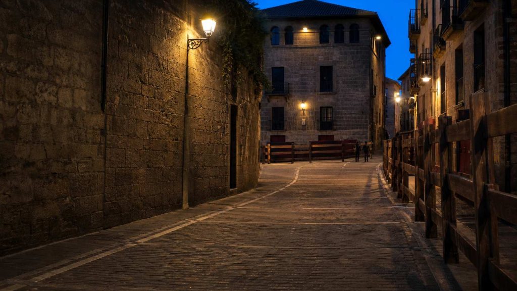 Vallado de madera en una calle histórica de Pamplona preparado para el Encierrillo de San Fermín al anochecer