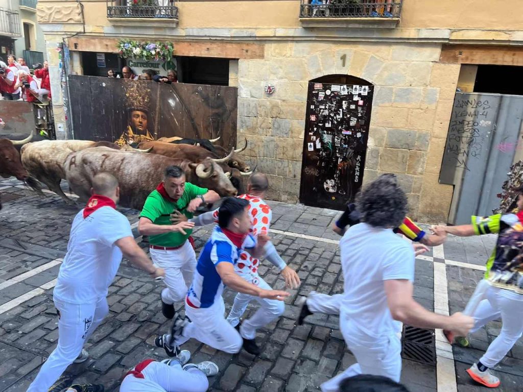 Toros y corredores en una calle del recorrido del encierro de San Fermín en Pamplona