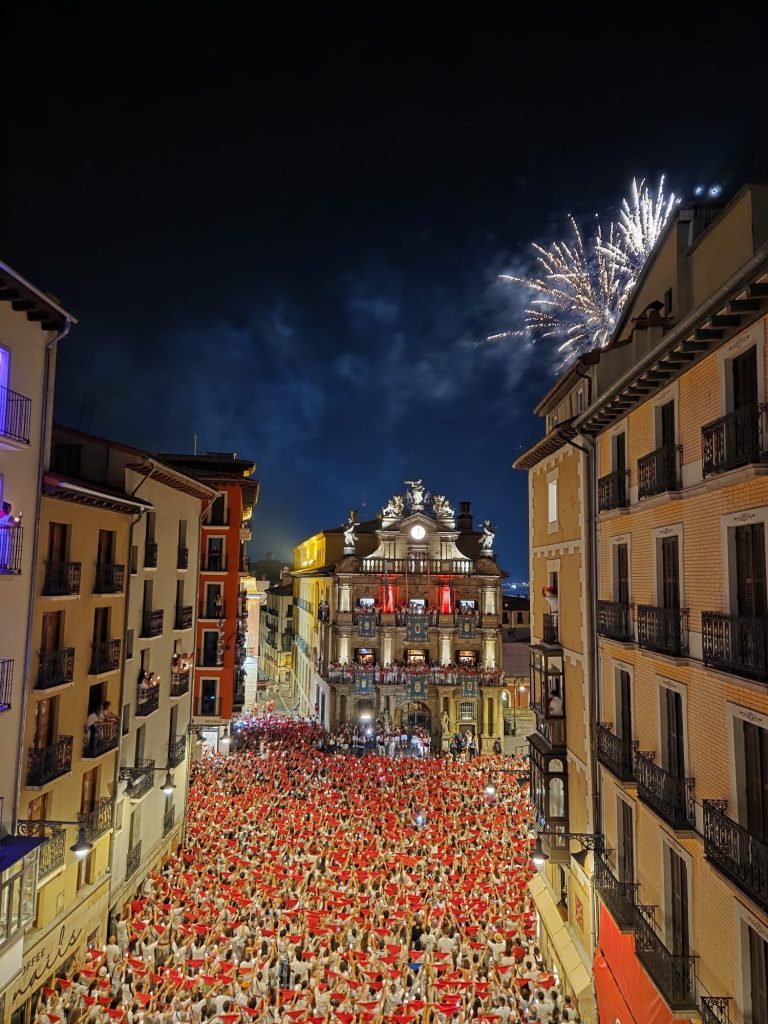 Plaza del Ayuntamiento de Pamplona llena de gente y fuegos artificiales en San Fermín